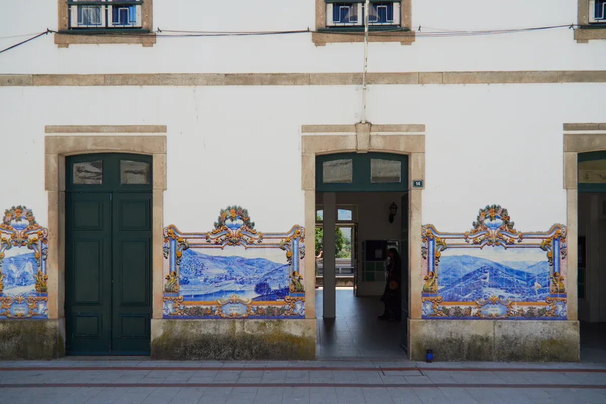 Azulejo panels of Douro Valley landscapes on a Douro line station facade, seen on a train Douro Valley wine tour from Porto